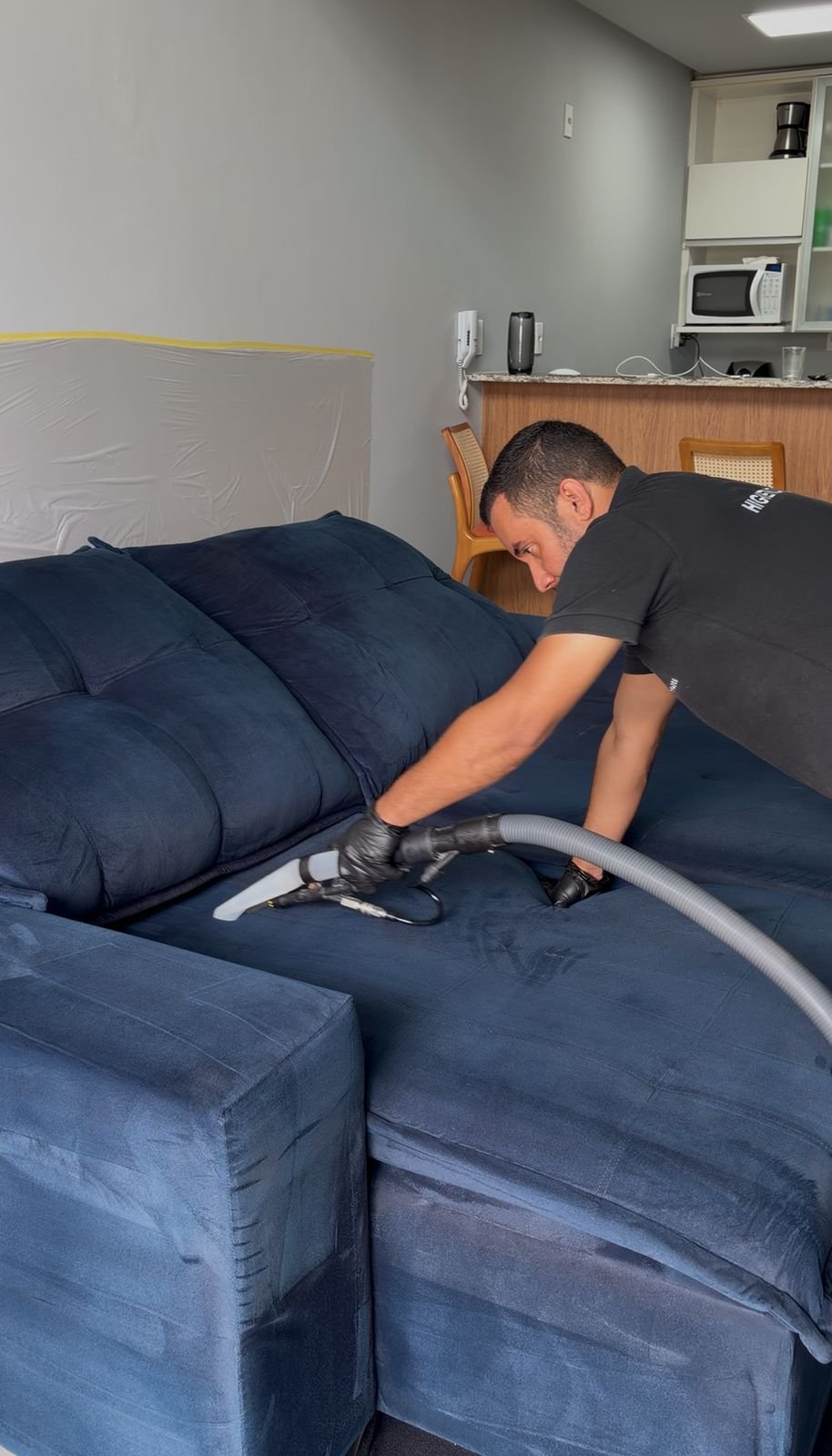 Técnico Clareô realizando higienização de sofá em domicílio