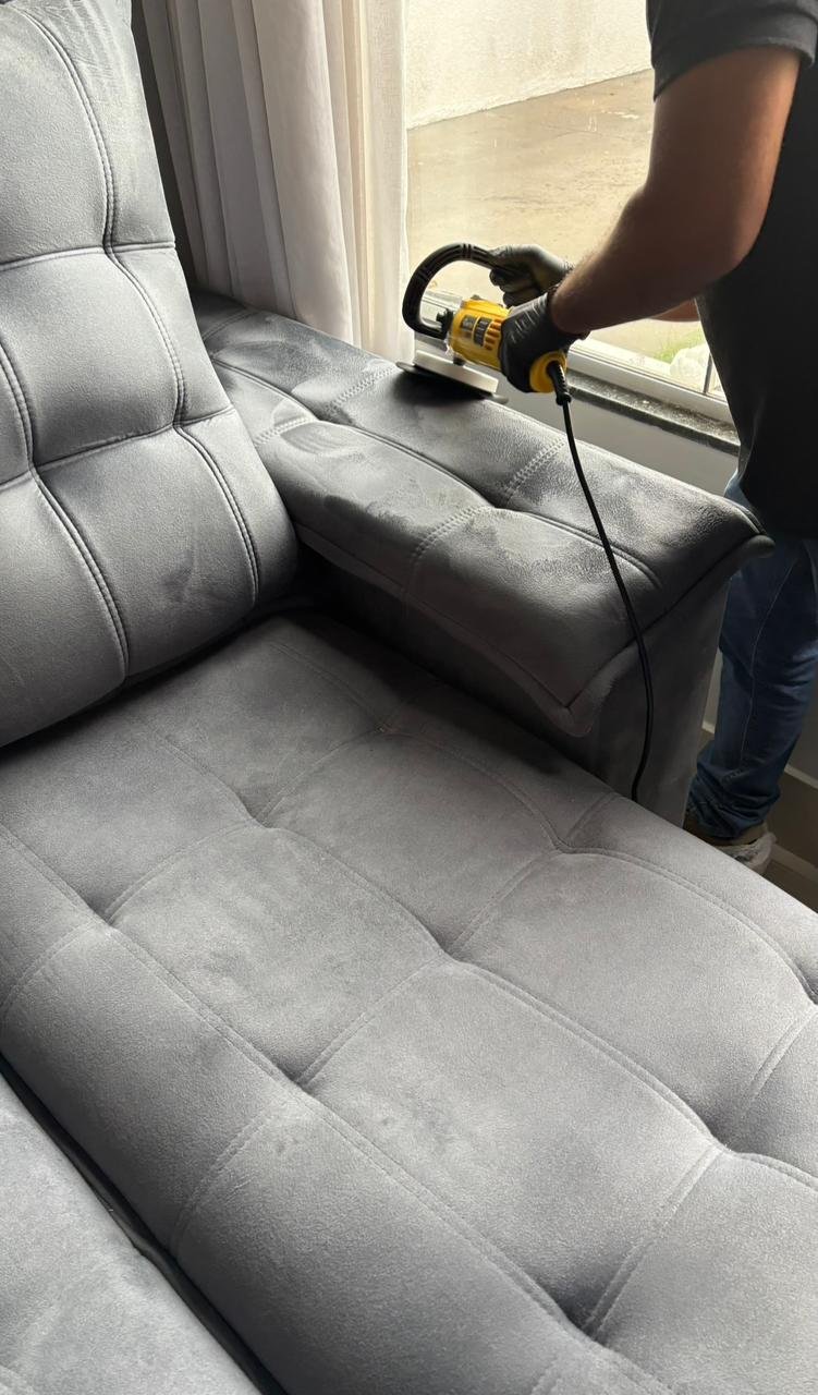 Técnico Clareô usando equipamento de higienização em sofá cinza